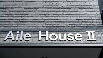 Un letrero que dice 'Aile House II' sobre una pared con textura.