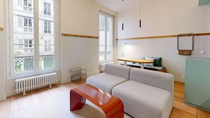 A modern living room with a sofa, a small table, and a radiator. - A400 JOIVY Charming 2-bed flat w/ shared spaces (Paris)