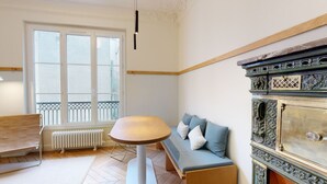 A room with a wooden bench, a round table, a sofa with cushions, a radiator, and a decorative cabinet. - JOIVY Pleasant 1-bed flat w/ shared courtyard (Paris)