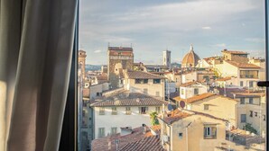 Un paisaje urbano que combina edificios históricos y modernos, incluyendo una torre destacada y una estructura en forma de cúpula.