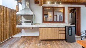 A modern kitchen with a built-in stove, wooden cabinets, and a refrigerator. - House w/ Pool 900m From the Beach, Arraial Ptg0030 (Porto Seguro)