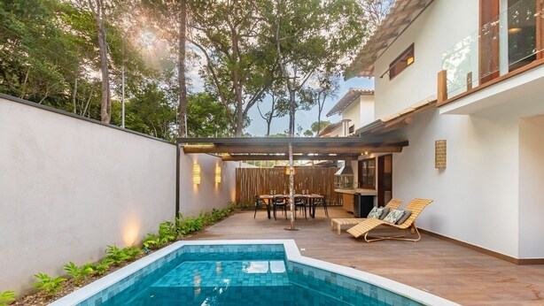 A backyard with a swimming pool, a covered patio area, and a dining table with chairs. - House w/ Pool 900m From the Beach, Arraial Ptg0030 (Porto Seguro)