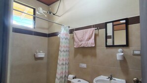 A small bathroom with a toilet, sink, and shower.