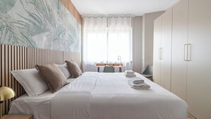 Une chambre d’hôtel moderne, dotée d’un grand lit, d’un bureau et d’une chaise.