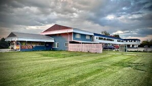 A two-story building with a flat roof and a fenced yard. - Hotel O (Oskaloosa)