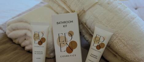 A bathroom kit with a shower gel, shampoo, and a box labeled 'EDEN COSMETICS.'