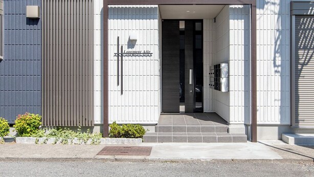 A modern building entrance with a sign reading "Logement Aile". - Logement Aile (Takasaki)