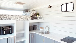 A compact kitchen with a sink, countertop, and a small window.