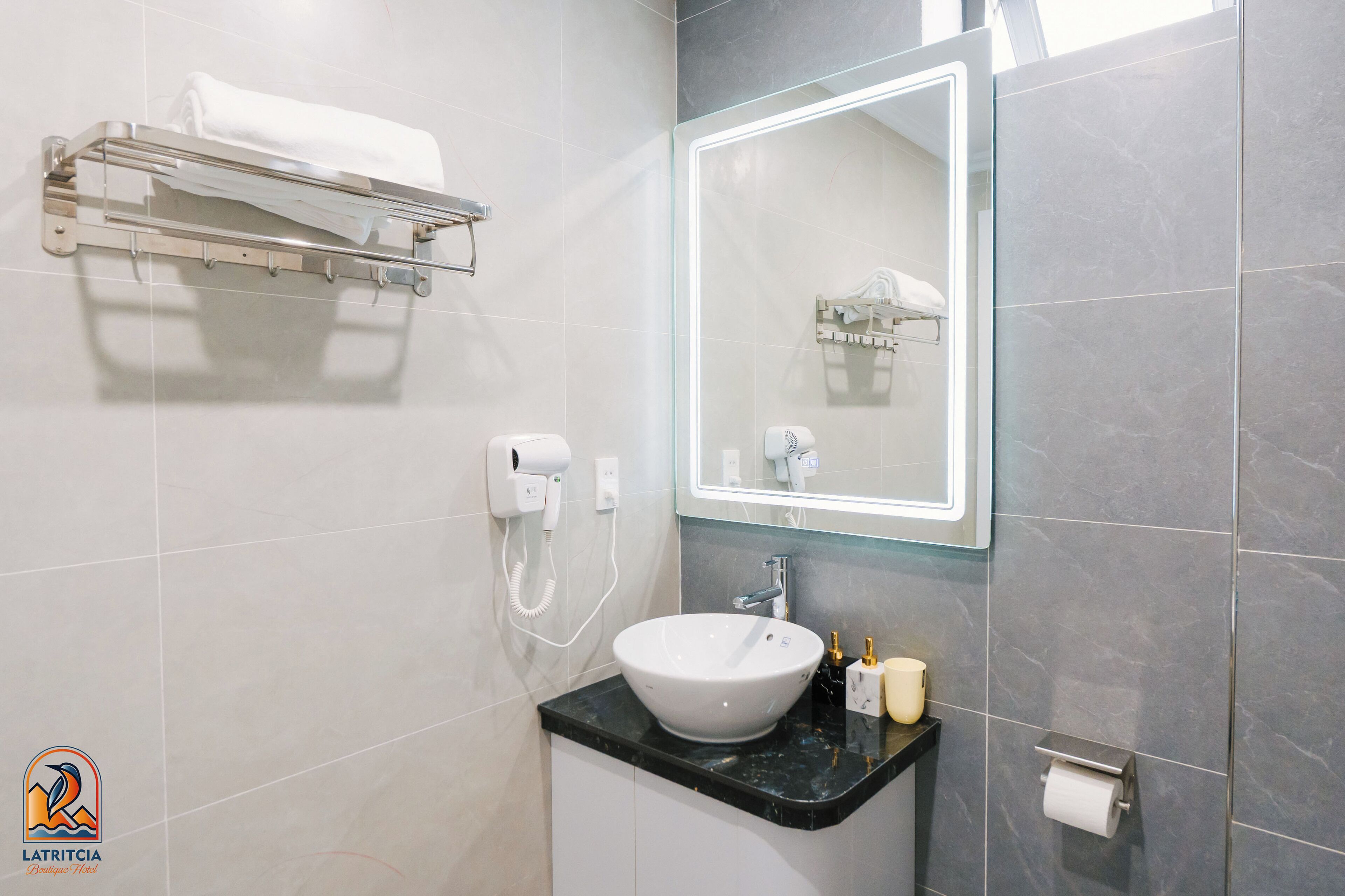 A modern bathroom with a white sink, a glass shower enclosure, and a towel rack.