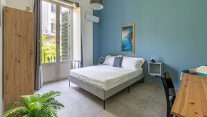 Une chambre à coucher avec un lit, une armoire en bois, une petite table et une chaise.