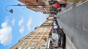 A street view with a row of shops, including a bridal shop, and a parked car.