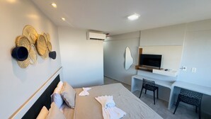Een moderne hotelkamer met een bed, bureau en televisie.