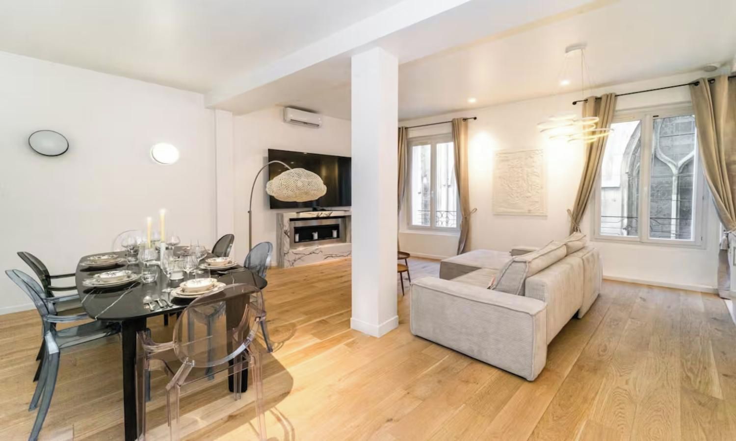 A modern living space with a dining area, a sofa, and a fireplace.