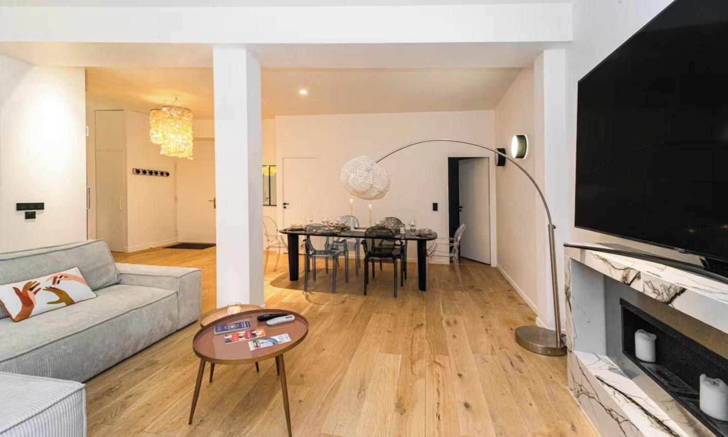 Un salon moderne avec un canapé, une table basse et un téléviseur à écran plat.