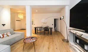 Un salon moderne avec un canapé, une table basse et un téléviseur à écran plat.