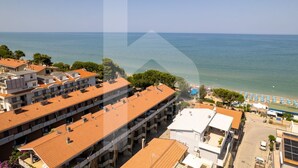 A coastal hotel with multiple floors, a beach view, and a parking area. - Homiday - Lungomare dei Pini, D2 (Pineto)