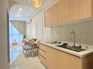 Una cocina moderna con armarios de madera, una isla grande con un fregadero y un comedor con mesa y sillas.