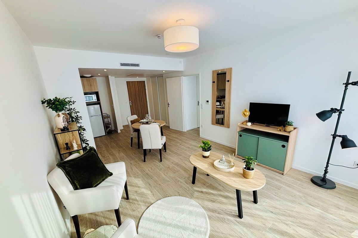 Ein modernes Wohnzimmer mit Essbereich, Küche und Fernseher.