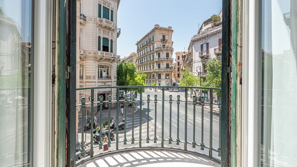 A view from a balcony overlooking a city street with historic buildings. - Panurban Apartments by Wonderful Italy (Palermo)