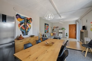 A modern kitchen with a refrigerator, wooden dining table, and chairs. - 'Isola Bella' Apartment with Mountain View, Private Terrace and Wi-Fi (Sottocastello)