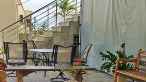 Un espacio al aire libre con bancos y mesas de madera bajo una carpa.