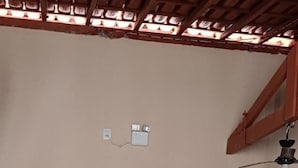 Un pasillo con una puerta de madera, un cartel que dice "Seja Bem Vindo" y dos carteles en las paredes.