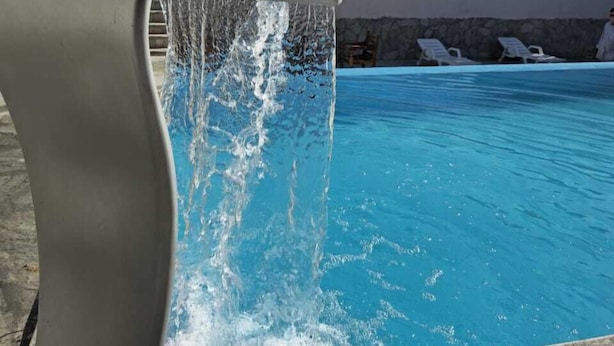 Una piscina con fuente de agua.