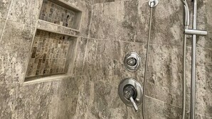 A shower with a rain showerhead, a handheld showerhead, and a handheld shower hose. - Charming studio & kitchenette in wonderful Palm Harbor with AC & laundry access (Palm Harbor)
