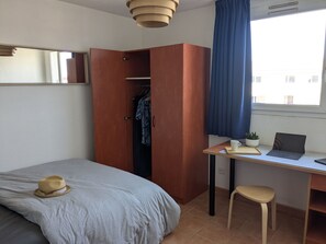 A bedroom with a bed, a desk with a laptop, a chair, a wardrobe, and a window with curtains. - Quiet studio in Avignon (Avignon)