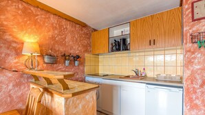 A kitchen with wooden cabinets, a countertop, a sink, a dishwasher, and a stove.