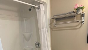 Een badkamer met een bad, toilet en douchegordijn.
