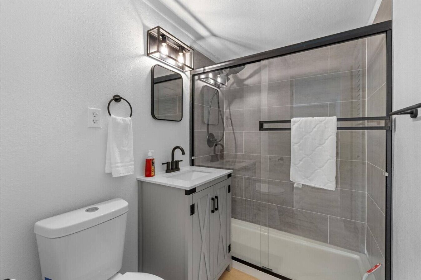 Un baño moderno con inodoro, lavamanos y cabina de ducha.