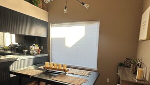 Una cocina moderna con una isla central, una mesa de comedor con bancos y un lámpara en el techo.