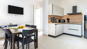 A modern kitchen with white cabinets, a microwave, and a built-in stove. - Apartment 'Flora' with Private Garden, Wi-Fi, and Air Conditioning (Cisternino)