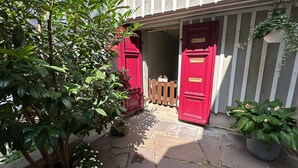 A stone-paved entrance with red doors and a wooden fence. - Harz-Bleibe Wernigerode, very centrally located. (Wernigerode)
