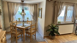 A dining area with a wooden table and chairs, a hanging light fixture, and a potted plant. - Harz-Bleibe Wernigerode, very centrally located. (Wernigerode)