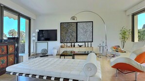 A modern living room with a sofa, a coffee table, a TV, and artwork on the wall.
