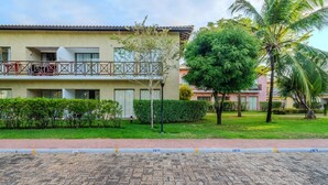 Un edificio residencial con balcón, un camino empedrado y un césped cuidado.