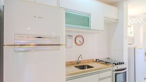 Una cocina con un refrigerador blanco, un microondas, una estufa y un lavaplatos.