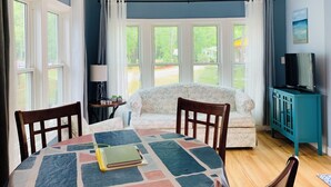 Una habitación acogedora con una mesa redonda, dos sillas, un sofá y un mueble para la televisión.