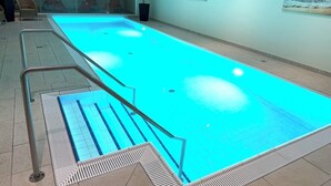 A swimming pool with a tiled deck, lounge chairs, and a potted plant. - Südwind 05 - apartment, close to the beach, swimming pool, sauna, parking, WLAN, and balcony (Zempin)