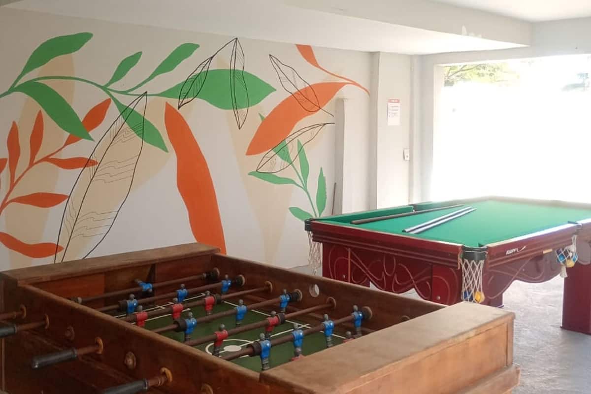 Una habitación con mesa de futbolín y mesa de billar, ambos en buen estado.