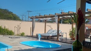 A pool area with two pools, lounge chairs, and a pergola. - Aruna Eco Pousada (Buzios)