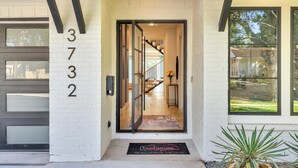 A modern house with a white exterior, a visible number '372' on the wall, and a glass door entrance leading to a staircase. - Fabulous 5-bedroom house in Dallas (Dallas)