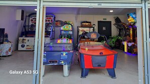An arcade area with various gaming machines, including a pool table and a racing game. - Mobilhome 6 pers (Vendays-Montalivet)