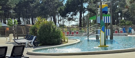 A swimming pool area with lounge chairs and a water fountain.