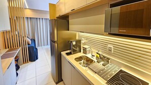 Une cuisine moderne équipée d’un four encastré, d’un four à micro-ondes et d’un évier avec un robinet au design contemporain.
