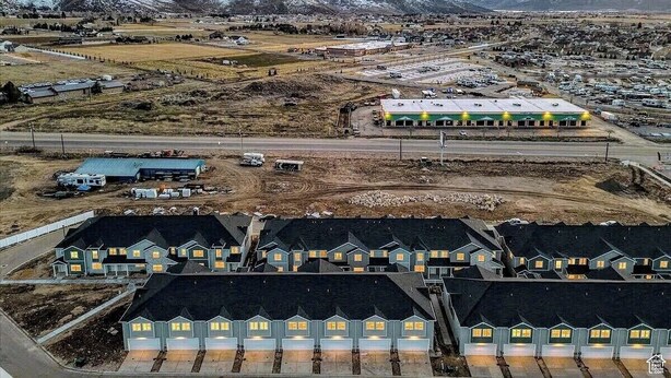 Una zona residencial con varias casas, un edificio grande y montañas al fondo.