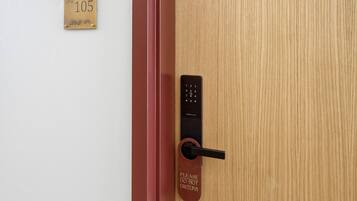 A door with a numeric keypad lock, a 'Please do not disturb' sign, and a room number sign.