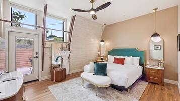 A bedroom with a bed, bedside tables, a desk, a ceiling fan, and a window.